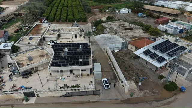 צילום רחפן של וילה בשכונה פרברית עם מערכת סולארית על גג שטוח